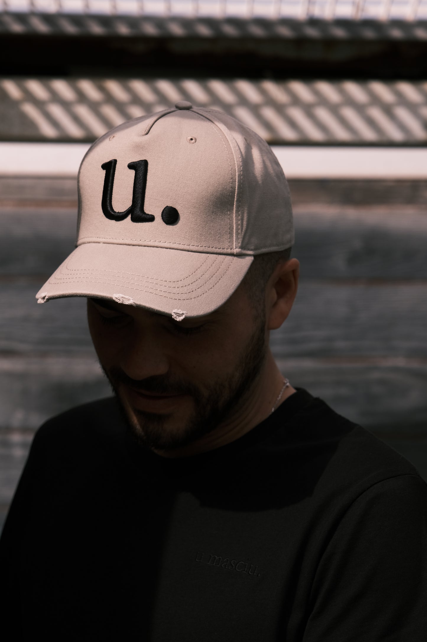 homme avec une casquette beige et un t-shirt noir