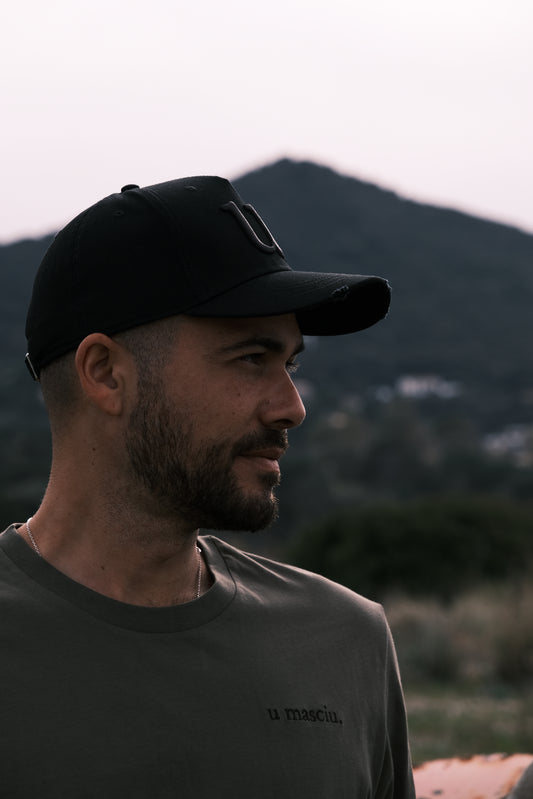 homme qui pore une casquette noire et un t-shirt kaki