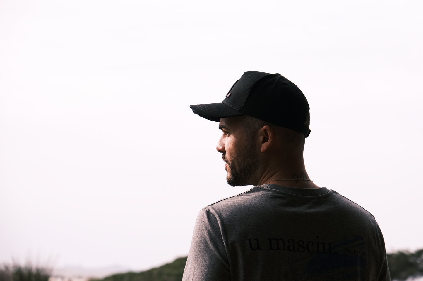 homme qui porte une casquette noire et un t-shirt gris