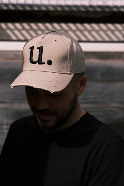 homme avec une casquette beige et un t-shirt noir